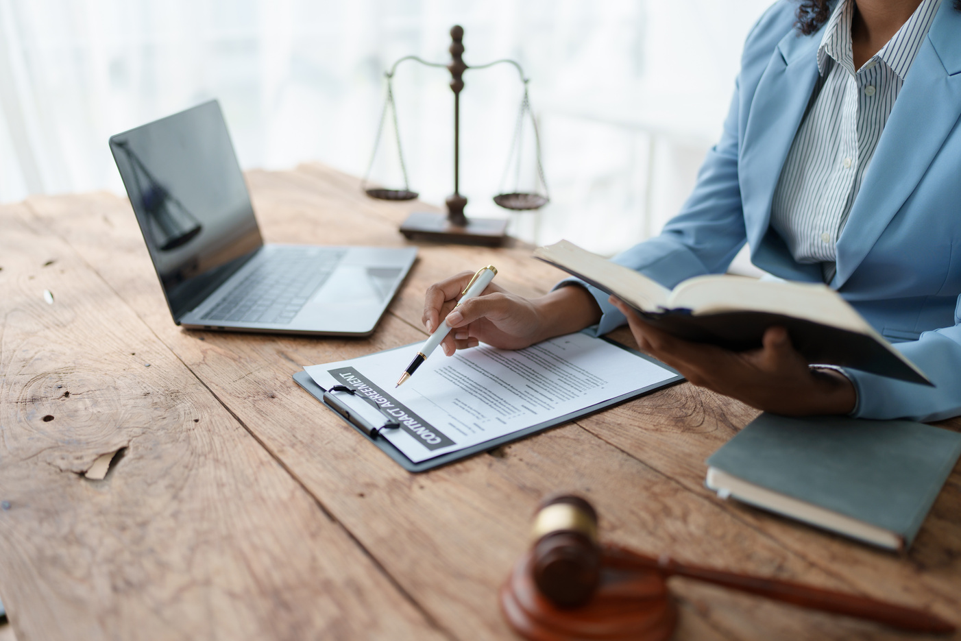 Young African American lawyer studying a case for a client and signing a legal contract to fight her opponent in court. Legal and lawyer concepts.